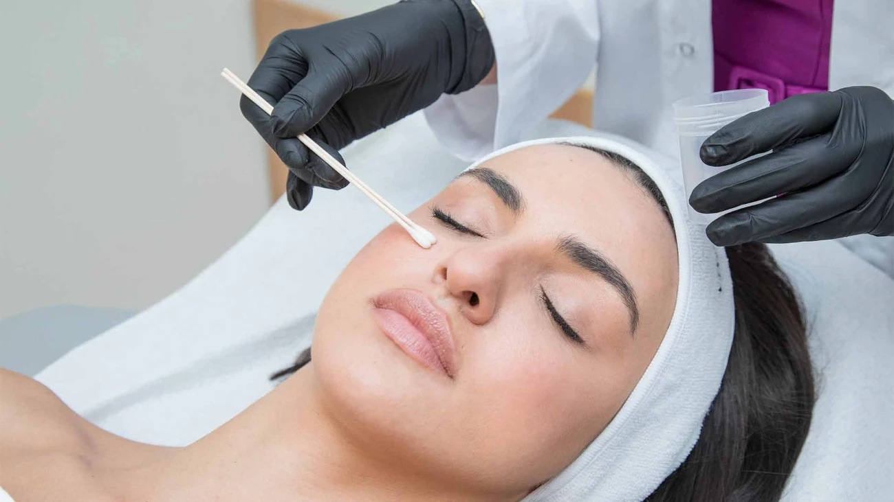 Εφαρμογή χημικού peeling στο πρόσωπο γυναίκας από γιατρό